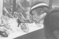 Frau beim Betrachten von Schuhen an der Mustermesse 1935